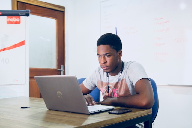 Student working on a college project on his computer